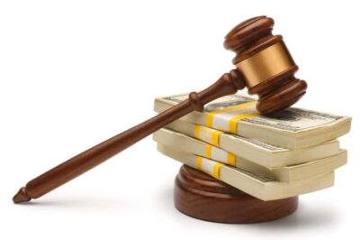Wooden Gavel Laying On Top Of A Stack Of Money Stock Photo