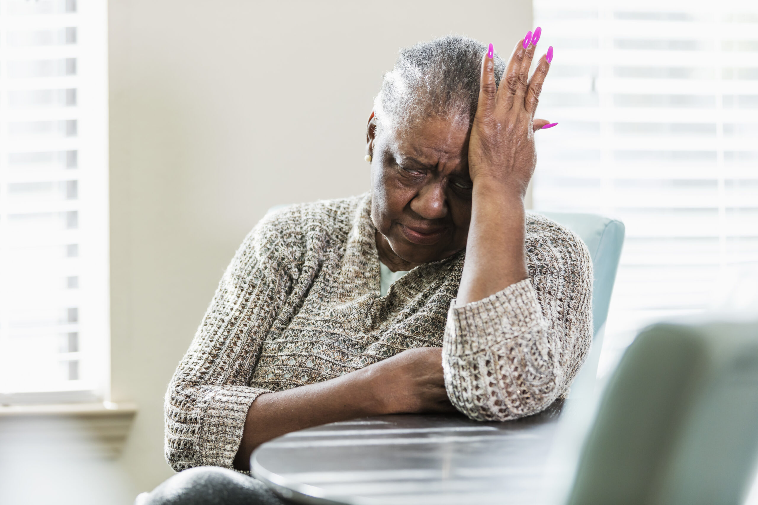Senior African-American woman with headache, upset