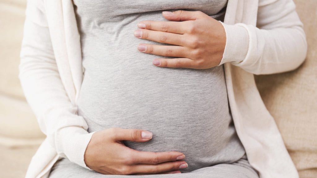 Pregnant Woman Holding Stomach Stock Photo