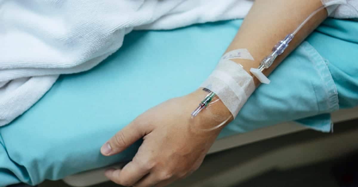 Woman In Pain In A Hospital Bed Stock Photo
