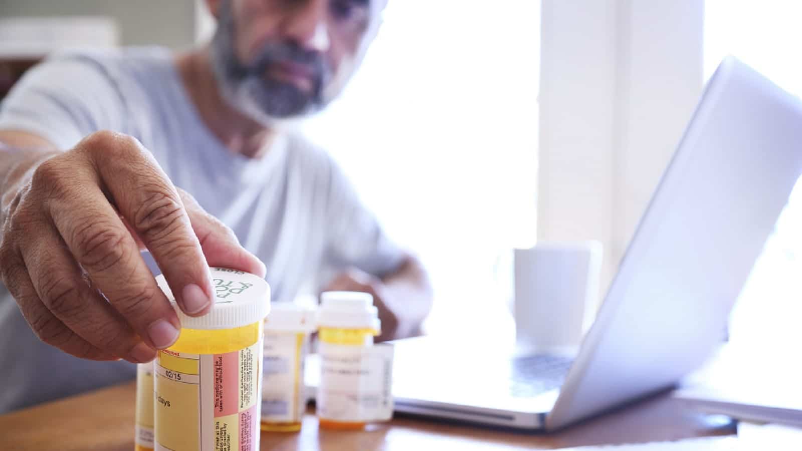 Mature Man Reaching For Prescription Pill Bottle