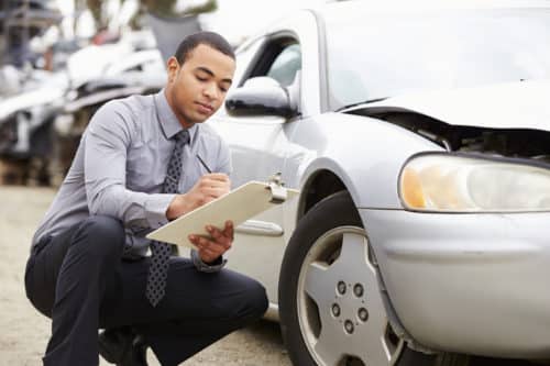 insurance adjuster inspecting vehicle damage after an accident in Phoenix, AZ